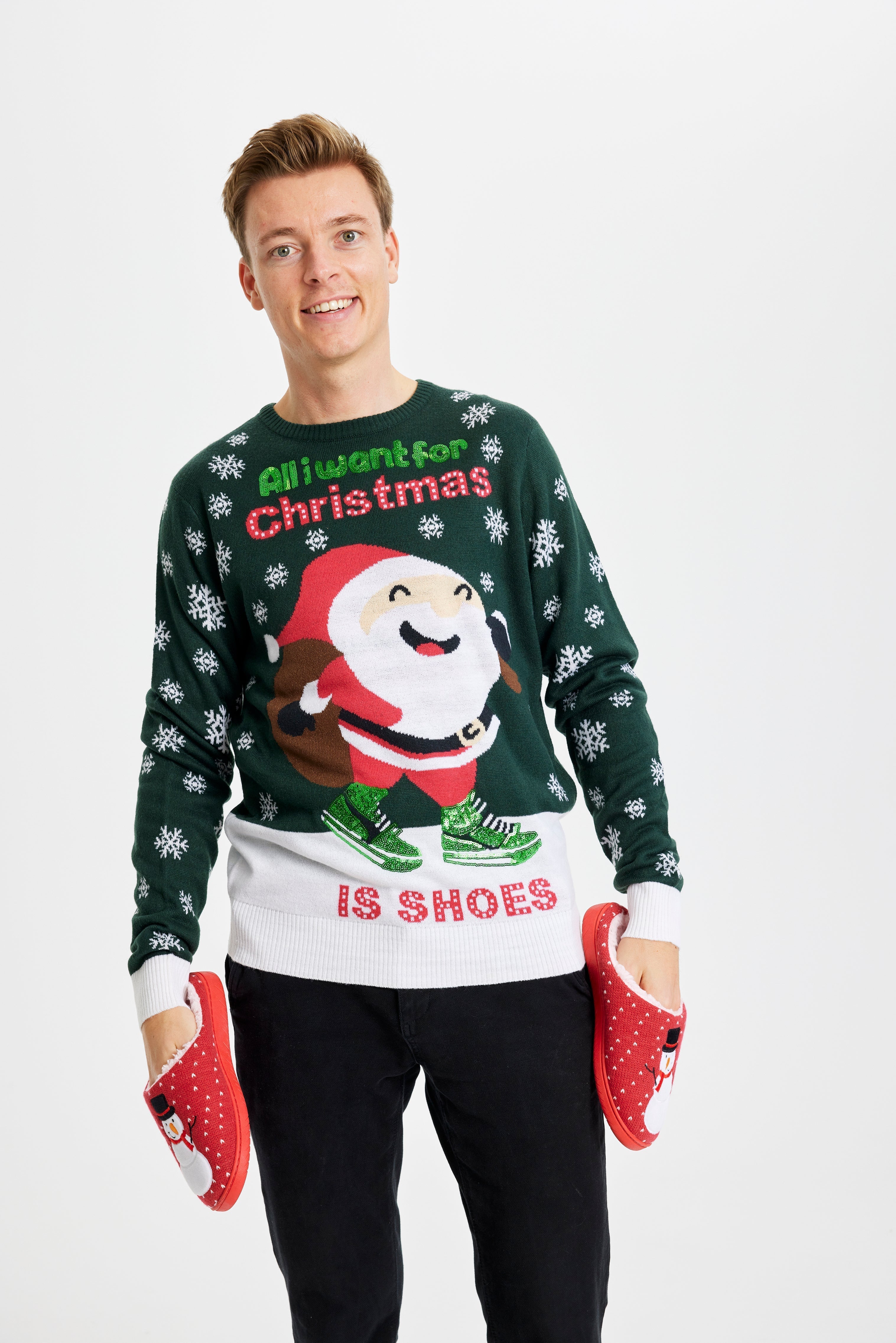 Een man draagt een groene en witte kersttrui met de quote